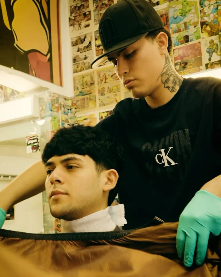 Barbero de la 5.55 preparando a un cliente